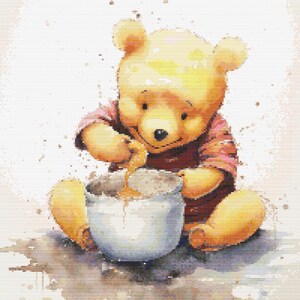 Pode incluir: Um urso amarelo vestindo uma camisa listrada vermelha e branca está sentado em uma superfície marrom e mexendo mel em uma panela branca. O fundo é bege claro com respingos de aquarela marrom.