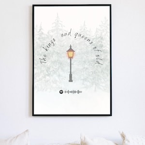 May include: Black framed art print featuring a winter scene with a lamppost and the text "The kings and queens of old." The print includes a Spotify code at the bottom. The background shows snow-covered trees.