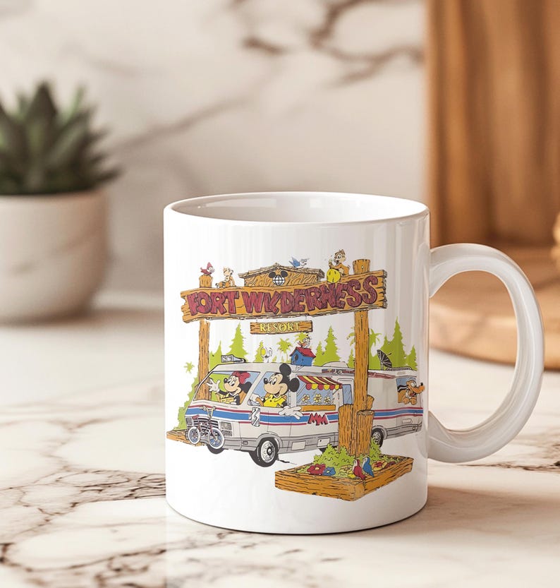K&ouml;nnte beinhalten: Wei&szlig;e Keramiktasse mit einer farbenfrohen Illustration von Mickey Mouse, Minnie Mouse und Pluto in einem Van mit dem Text "FORT WILDERNESS RESORT". Die Tasse hat einen gebogenen Griff und ist f&uuml;r hei&szlig;e oder kalte Getr&auml;nke geeignet.