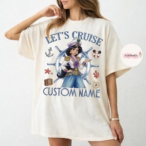 Pu&ograve; includere: T-shirt color crema con grafica di una donna in uniforme da capitano, circondata da elementi nautici. Il testo "LET'S CRUISE" e "CUSTOM NAME" sono stampati in blu. Include un'ancora, una stella marina e una bussola.