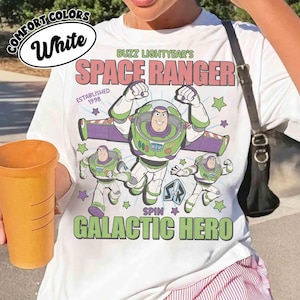 May include: White t-shirt featuring Buzz Lightyear's Space Ranger design. The graphic includes Buzz Lightyear in a green and white spacesuit, with the text "SPACE RANGER" and "GALACTIC HERO". The shirt also has the text "ESTABLISHED 1998".