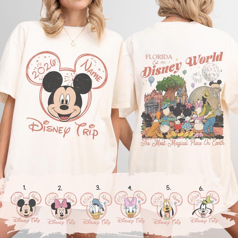 K&ouml;nnte beinhalten: Cremefarbenes T-Shirt mit einem Mickey Mouse-Motiv und dem Text "Disney Trip" und "2020". Auf der R&uuml;ckseite des Shirts ist eine farbenfrohe Disney World-Szene mit dem Text "Florida Disney World" abgebildet.