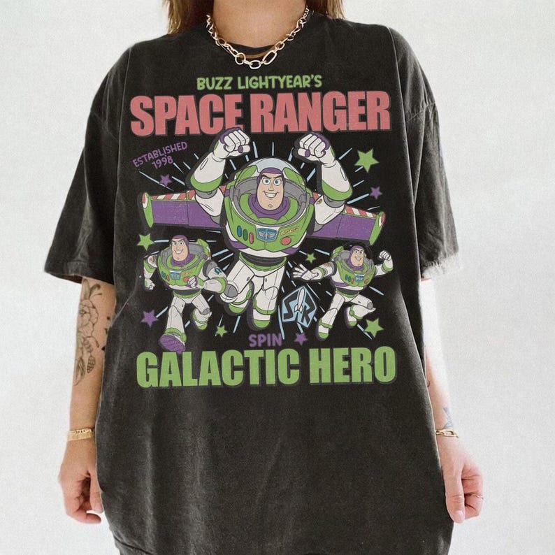 May include: Black t-shirt featuring Buzz Lightyear from Toy Story. The design includes the text "Buzz Lightyear's Space Ranger" and "Galactic Hero" with images of the character. Established 1998.
