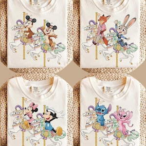May include: Four cream-colored t-shirts with cartoon carousel designs. Each shirt features a different set of characters riding a carousel horse. The characters include Chip and Dale, Nick Wilde and Judy Hopps, Mickey and Minnie Mouse, and Stitch and Angel.