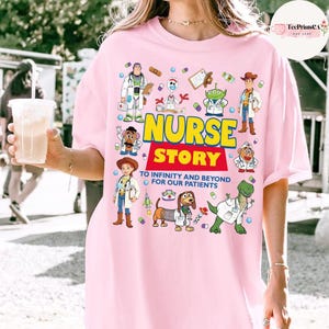 May include: A pale pink t-shirt with a vibrant graphic of cartoon characters dressed as medical professionals. The words "NURSE STORY" are in bold, with the slogan "TO INFINITY AND BEYOND FOR OUR PATIENTS" below.