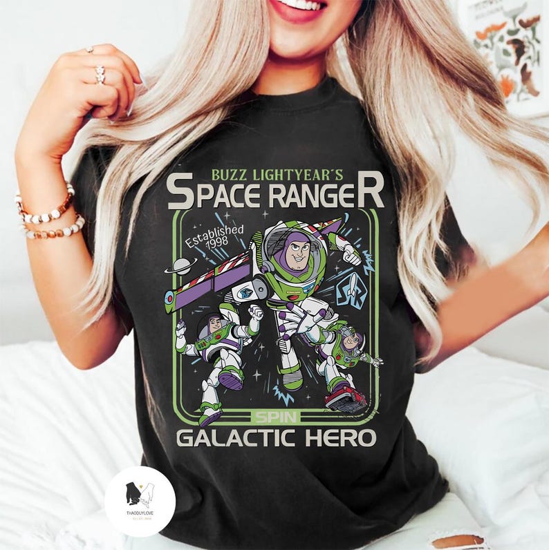 Puede incluir: Camiseta negra con un gr&aacute;fico de Buzz Lightyear de Toy Story. El dise&ntilde;o incluye el texto "Buzz Lightyear's Space Ranger" y "Galactic Hero". El gr&aacute;fico es en verde, morado, blanco y negro.
