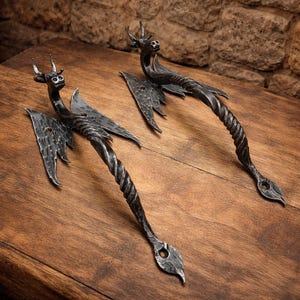 Könnte beinhalten: Ein Set aus drei Keramikbechern mit gesprenkelter, matter Oberfläche. Die Becher sind in Creme-, Hellgrau- und Dunkelgrautönen gehalten. Jeder Becher hat ein schlichtes, minimalistisches Design und einen abgerundeten Henkel.