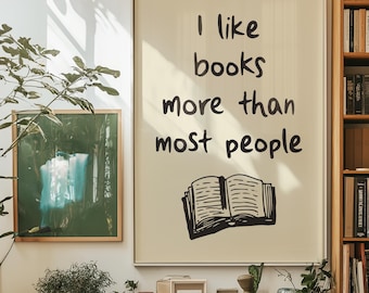 May include: A beige framed print with black text that reads "I like books more than most people" and a black and white illustration of an open book.