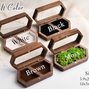 Op de afbeelding: Houten sieradenkistjes met doorzichtige deksels, verkrijgbaar met zwarte, witte, bruine en met mos gevulde interieurs. De kistjes zijn zeshoekig en meten 10 x 5 x 2,8 cm.