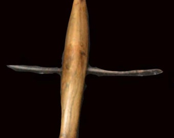 May include: A wooden arrowhead with a pointed tip and a smooth, brown finish. The arrowhead is mounted on a wooden cross.