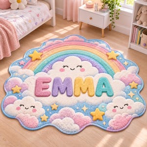 May include: A scalloped, cloud-shaped area rug featuring a pastel rainbow arch, smiling white clouds, and yellow stars. The name EMMA is displayed in large, colorful, textured block letters across the center of the rug design.