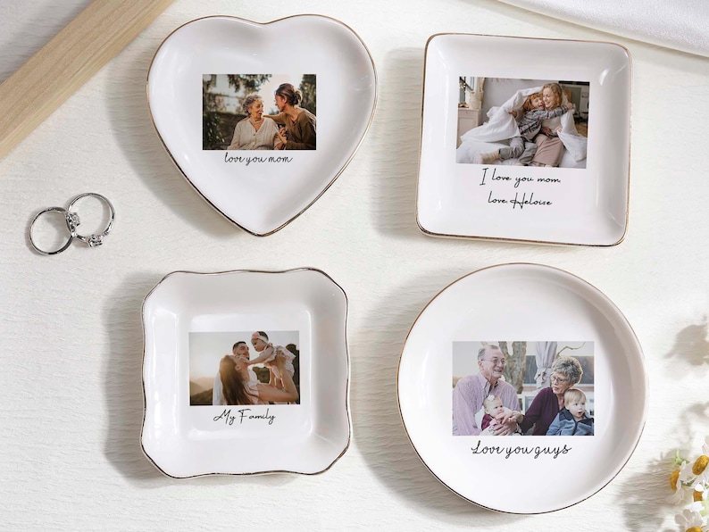 May include: Four white ceramic trinket dishes in heart, square, and round shapes, each with a gold rim and a family photo. Text on the dishes reads "love you mom", "I love you mom, Love Heloise", "My Family", and "Love you guys".