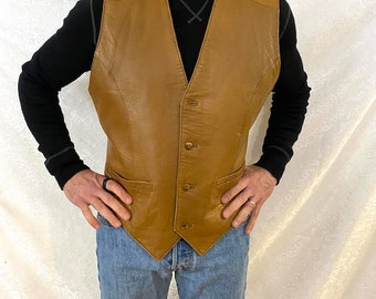 May include: A brown leather vest with a button-up front and two pockets. The vest has a pointed bottom.