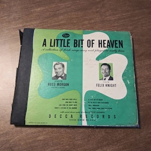 Peut inclure: Une pochette d'album de disque vinyle vintage avec un fond vert et un titre blanc : "A Little Bit of Heaven." L'album présente une collection de chansons irlandaises chantées et jouées en "vraiment temps." L'album présente deux musiciens : Russ Morgan et Felix Knight.