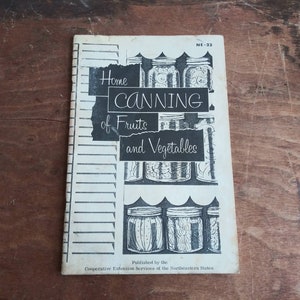 May include: A vintage book titled "Home Canning of Fruits and Vegetables" with a black and white illustration of jars of preserved food. The book is published by the Cooperative Extension Services of the Northeastern States and has the number NE-23 on the cover.
