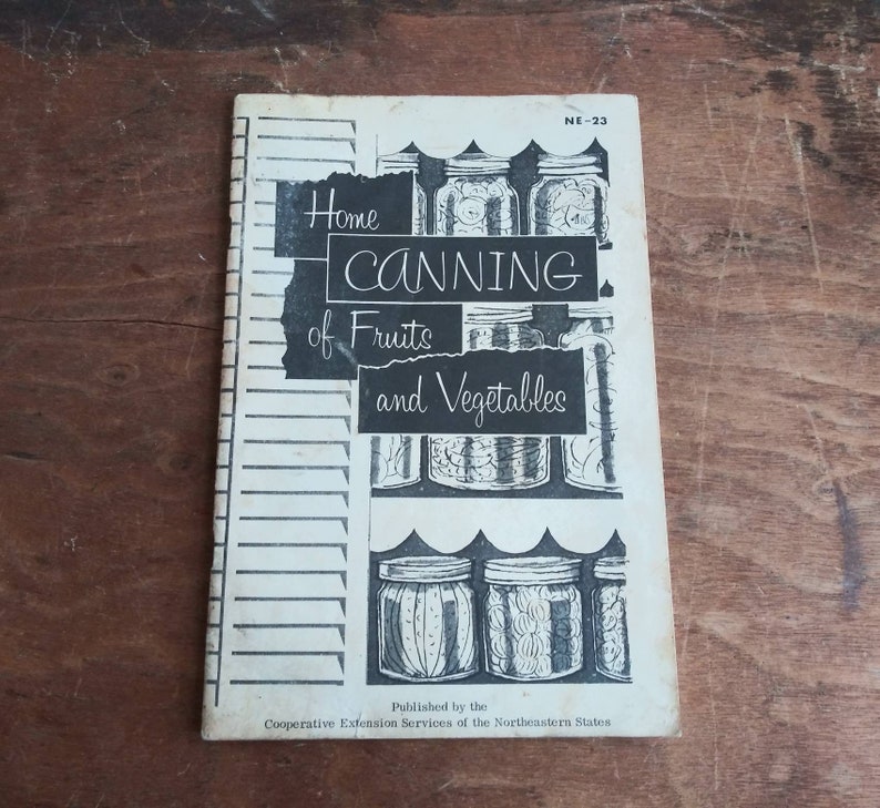 May include: A vintage book titled "Home Canning of Fruits and Vegetables" with a black and white illustration of jars of preserved food. The book is published by the Cooperative Extension Services of the Northeastern States and has the number NE-23 on the cover.