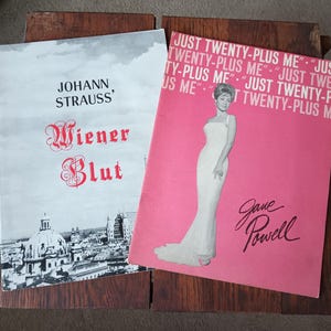 May include: A pink program for a musical performance of "Wiener Blut" by Johann Strauss, featuring a photo of Jane Powell in a white gown. The text "Just Twenty-Plus Me" is repeated multiple times on the program.