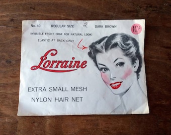 May include: Vintage "Lorraine" nylon hair net packaging. The package features a retro illustration of a woman with dark hair and red lipstick. Text includes "Extra Small Mesh" and "Dark Brown".