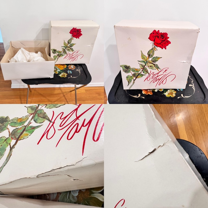 May include: White box with a red rose illustration and red script. The box is sitting on a black tray with a floral design. Another box is open, revealing white tissue paper.