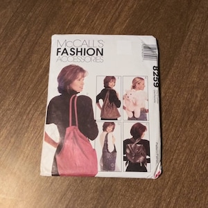 May include: McCall's Fashion Accessories pattern 8259 for a tote bag, hobo bag, and backpack. The pattern includes instructions for making three different styles of bags. The bags are shown on models wearing different outfits.