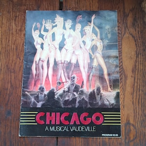 May include: A vintage programme cover for the musical "Chicago." The artwork features a group of stylized female dancers in lingerie and hats, with a band playing below. The title "CHICAGO" is in red, with the text "A MUSICAL VAUDEVILLE" below.