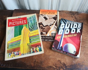 May include: Three vintage guidebooks for the 1939 New York World's Fair. The guidebooks are titled "Official Pictures", "The General Motors Exhibit Building", and "Official Guide Book".