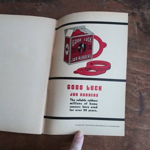 May include: A vintage Good Luck Jar Rubber advertisement with a red and white box and red rubber rings. The text reads "Good Luck Jar Rubbers. The reliable rubbers millions of home canners have used for over 20 years."