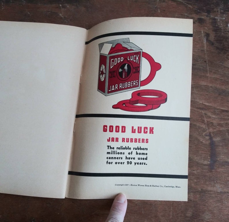 May include: A vintage Good Luck Jar Rubber advertisement with a red and white box and red rubber rings. The text reads "Good Luck Jar Rubbers. The reliable rubbers millions of home canners have used for over 20 years."