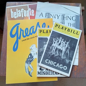 Puede incluir: Una colección de programas de teatro antiguos. Los títulos incluyen "Great", "A Funny Thing Happened on the Way to the Forum" y "Chicago". El programa "Great" tiene una portada amarilla con letras azules y una ilustración de dibujos animados.