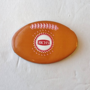May include: Orange and white football-shaped magnet with the words "RICH'S" in red lettering inside a white circle with a red starburst design.