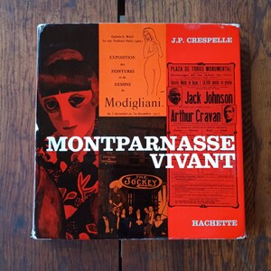 May include: A vintage book cover with a red, orange, and black design. The cover features the text "Montparnasse Vivant" in large white letters, along with illustrations and text about Modigliani and other artists. The book is from Hachette.