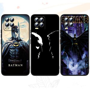 Könnte beinhalten: Drei schwarze Handyhüllen mit Batman-Designs. Eine Hülle zeigt Batman vor einem Mond, eine andere hat eine weiße Silhouette von Batmans Gesicht, und die dritte zeigt Batman mit Flügeln über einer Stadt. Das Wort "BATMAN" ist auf einer Hülle aufgedruckt.