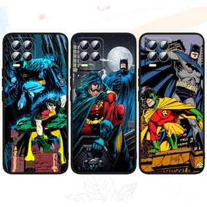 Może przedstawiać: Trzy etui na telefon z komiksowymi ilustracjami Batmana i Robina. Etui prezentują żywe kolory i dynamiczne pozy postaci na ciemnych tłach. Każde etui ma inny design, z Batmanem i Robinem w różnych scenach akcji.
