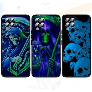 Op de afbeelding: Drie telefoonhoesjes met donkere ontwerpen. Eén heeft een Grim Reaper met een zeis, een andere toont een Grim Reaper met een zandloper en de derde toont een cluster van blauwe schedels. Elke hoes heeft een zwarte rand en een camera-opstelling.
