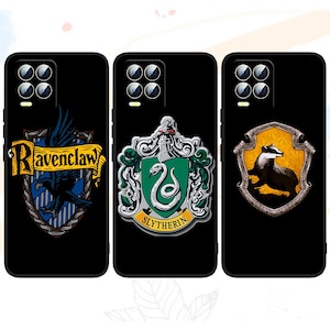 May include: Three black phone cases with different Harry Potter house crests. The first case features the Ravenclaw crest with a blue and silver eagle. The second case features the Slytherin crest with a green snake. The third case features the Hufflepuff crest with a yellow badger.