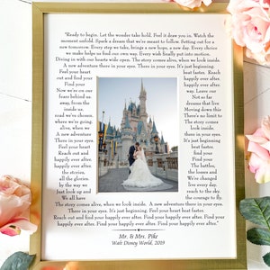 May include: A wedding photo of a couple in front of Cinderella's Castle at Walt Disney World. The photo is framed with a gold frame and has a quote about finding your happily ever after. The quote reads, "Ready to begin. Let the wonder take hold. Feel it draw you in. Watch the moment unfold. Spark a dream that we're meant to follow. Setting out for a new tomorrow. Every step we take, brings a new hope, a new day. Every choice we make helps us find our own way. Every wish finally put into motion. Diving in with our hearts wide open. The story comes alive, when we look inside. A new adventure there in your eyes. There in your eyes. It's just beginning. Feel your heart out and find your Find your Now we're on our fears behind us. away, from the inside us. road we've chosen. where we're going. alive, when we A new adventure There in your eyes. Feel your heart Reach out and beat faster. Reach happily ever after. happily ever after. way. Leave our Not so far dreams that live Moving down this There's no limit to The story comes look inside. there in your eyes. It's just beginning beat faster. find your Find your The battles, happily ever after. happily ever after. the stories, the losses and all the glories. We're changed by the way we live every day. Just look up and reach to the sky. We all have the courage to fly. The story comes alive, when we look inside. A new adventure there in your eyes. There in your eyes. It's just beginning. Feel your heart beat faster. Reach out and find your happily ever after. Find your happily ever after. Find your happily ever after. Find your happily ever after. Find your happily ever after." Mr. & Mrs. Pike Walt Disney World, 2019