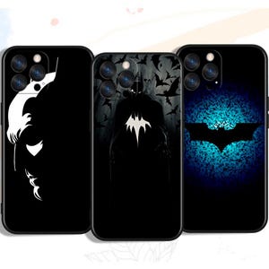 Może przedstawiać: Trzy czarne etui na telefon z motywami Batmana. Jedno etui ma białą sylwetkę twarzy Batmana, drugie przedstawia Batmana z nietoperzami, a trzecie ma logo Batmana na niebieskim tle.