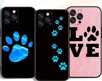 May include: Three phone cases with paw print designs. One black case features a blue paw print with a water-like effect. Another black case has a trail of blue paw prints. A pink case displays the word "LOVE" and a black paw print.
