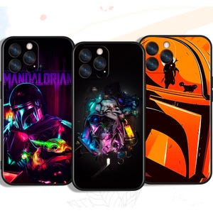 Può includere: Tre custodie nere per telefono con grafiche colorate. Una custodia presenta il testo "MANDALORIAN" con una figura con elmetto e una piccola creatura verde. Un'altra ha un design dettagliato del personaggio e la terza mostra un elmetto arancione.