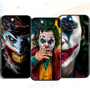 Può includere: Tre custodie nere per telefono con immagini del personaggio Joker. Le custodie mostrano diverse interpretazioni artistiche del volto di Joker, con colori vivaci e opere d'arte dettagliate. Le custodie sono progettate per uno smartphone.