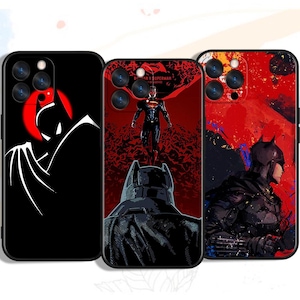 Może przedstawiać: Trzy czarne etui na telefon z postaciami z DC Comics. Jedno etui ma białą sylwetkę Batmana na czarnym tle. Inne przedstawia Batmana i Supermana z napisem "Batman v Superman". Trzecie etui przedstawia Batmana w czerwono-czarnym wzorze.