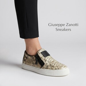 Puede incluir: Zapatillas sin cordones con estampado de piel de serpiente en beige y negro. Los zapatos tienen una cremallera negra y un parche de cuero negro. La suela es blanca. El texto "Giuseppe Zanotti Sneakers" es visible.