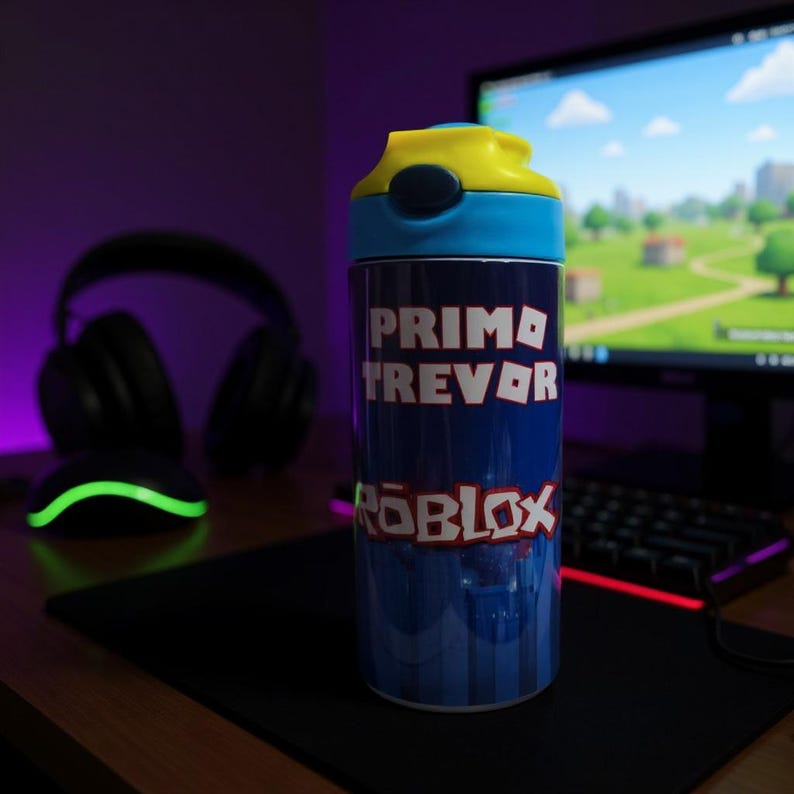 K&ouml;nnte beinhalten: Eine blau-gelbe Wasserflasche mit dem Text "PRIMO TREVOR" und dem Roblox-Logo. Die Flasche hat einen blauen K&ouml;rper mit vertikalem Streifendesign und einen gelben Klappdeckel. Der Hintergrund umfasst einen Computermonitor und Gaming-Zubeh&ouml;r.