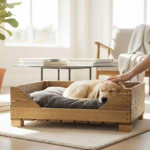 May include: A rectangular pet bed constructed from stained brown wood with a low-profile frame and short legs. Inside the wooden structure lies a soft, dark gray rectangular cushion, providing a comfortable resting space for a small dog.
