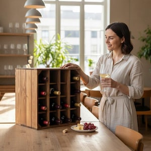 Op de afbeelding: Een vierkant houten wijnrek met meerdere rastercompartimenten waarin diverse wijnflessen staan. Het rek is gemaakt van lichtbruin hout met zichtbare houtnerven en heeft een gestructureerd ontwerp met een open voorzijde.