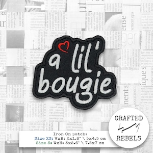 Può includere: Toppa termoadesiva nera con la scritta "a lil' bougie" in corsivo bianco e un piccolo cuore rosso. La toppa misura circa 7,5 cm x 7 cm. La toppa è di Crafted Rebels.