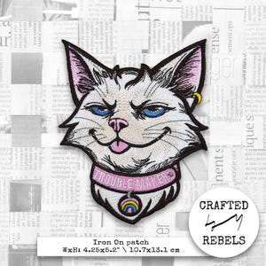 Puede incluir: Parche bordado para planchar con la cara de un gato blanco con ojos azules, nariz rosa y lengua rosa. El gato lleva un collar rosa con la inscripción "TROUBLE MAKER". El parche mide 10,7x13,1 cm.