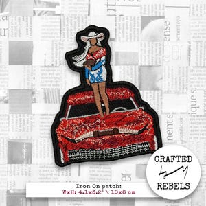 May include: Embroidered iron-on patch featuring a woman in a cowboy hat and dress standing on a red car. The patch is outlined in black and includes the text "Crafted by Rebels". The patch measures 4.1x3.2 inches.