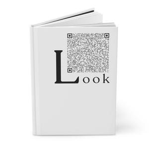 以下が含まれることがあります： 表紙に「Look」の文字が印刷された白い本。文字「L」は大きく黒く、文字「ook」は小さく黒いフォントで書かれています。「Look」という単語の上にQRコードが印刷されています。