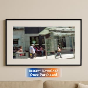 May include: A blurred photograph of a city street with people walking past a shop front and a bus stop. The shop front has a sign that says "Starbucks".